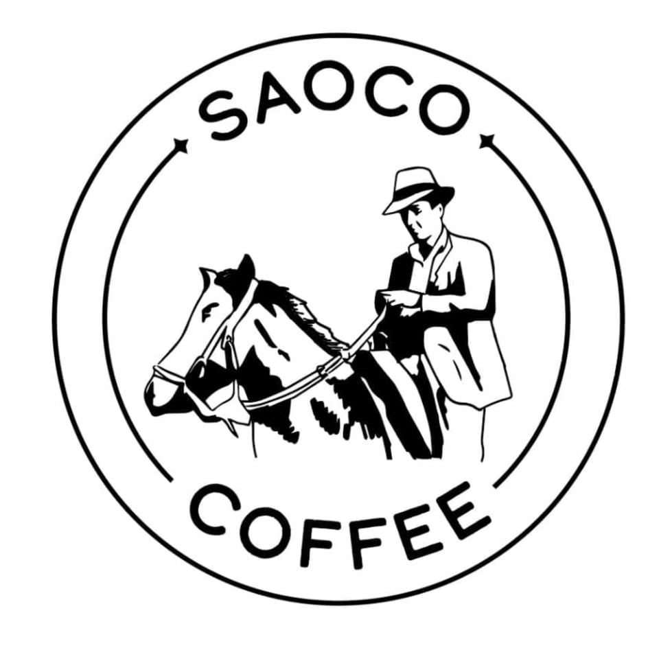 Saoco Coffee logo with a man in a hat riding a horse, encircled by text.